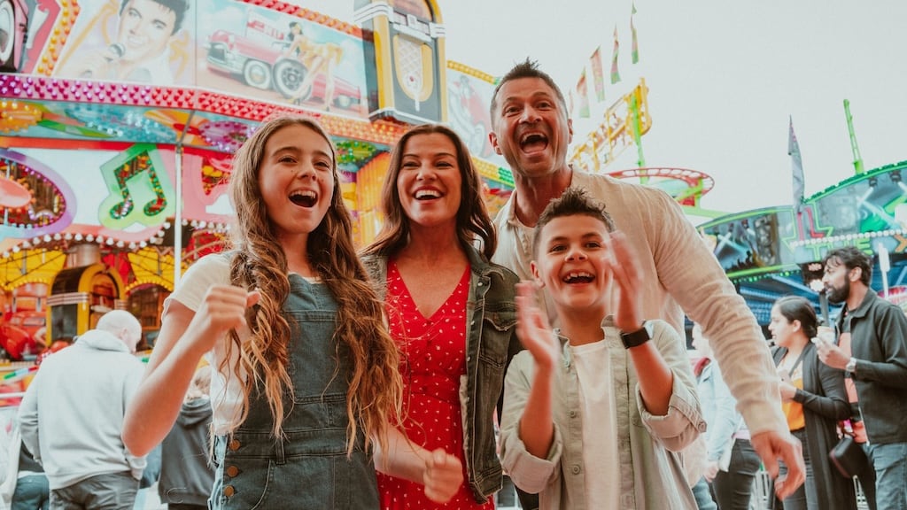 Sideshow Alley illuminated with bright lights and carnival rides at night
